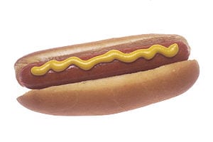 A cooked hot dog garnished with mustard.