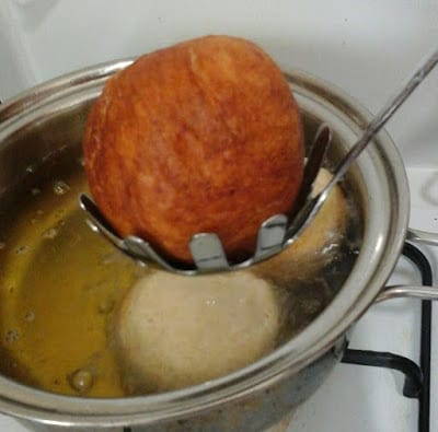 Frying Nigerian egg roll in oil in a pot