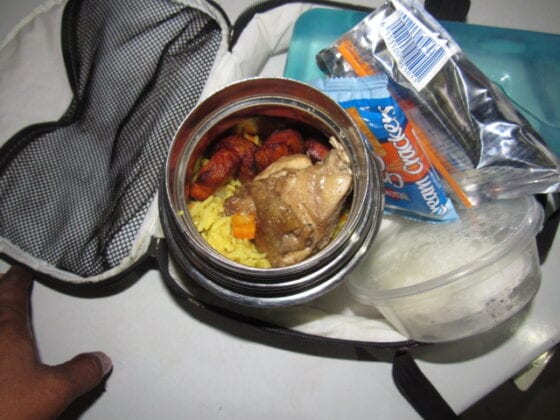 Nigerian school lunchbox meal of fried rice with chicken and plantain